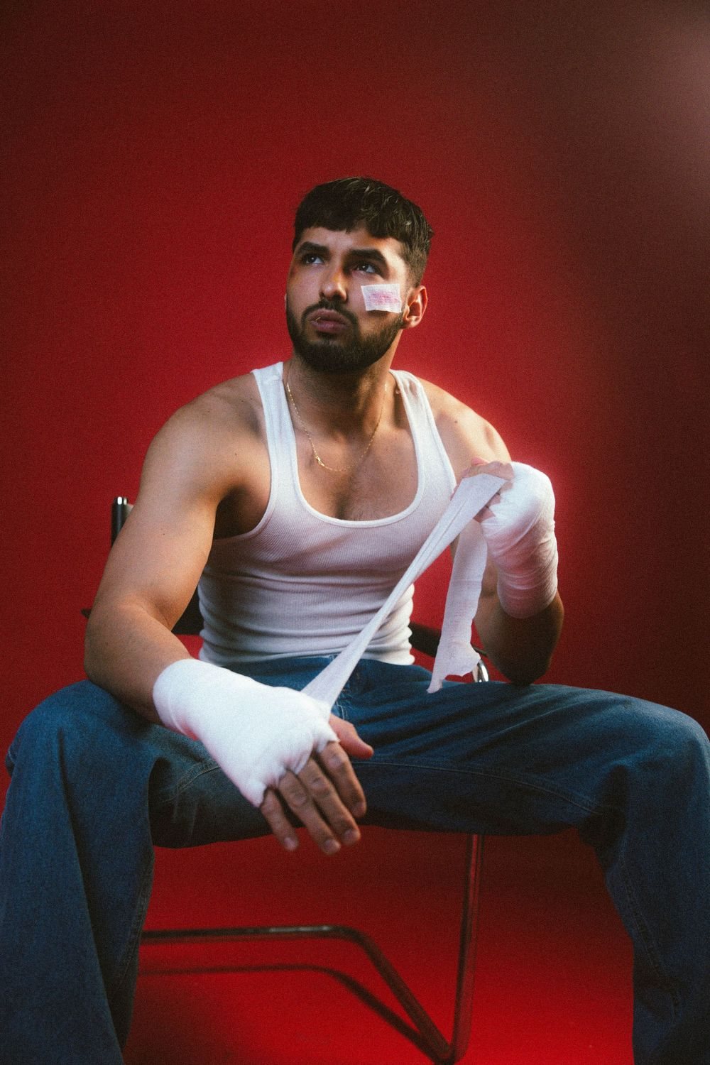 Man with taped hands on a red backdrop